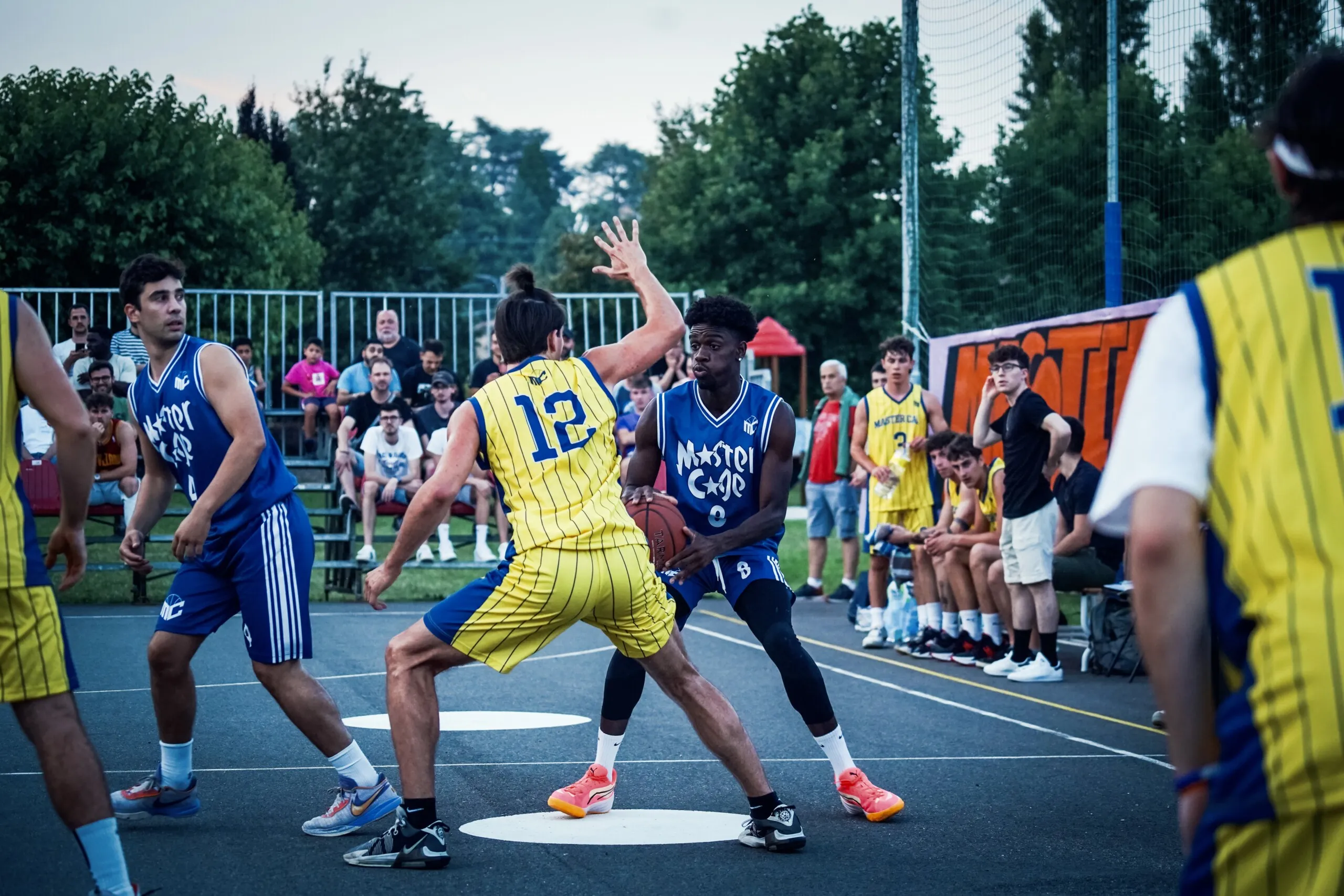 Campo da streetball urbano con giocatori in azione, atmosfera cinematografica